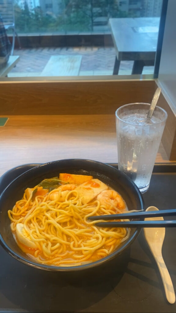 School lunch tray with laksa noodle soup and a lemon drink—authentic Southeast Asian meal during study abroad.