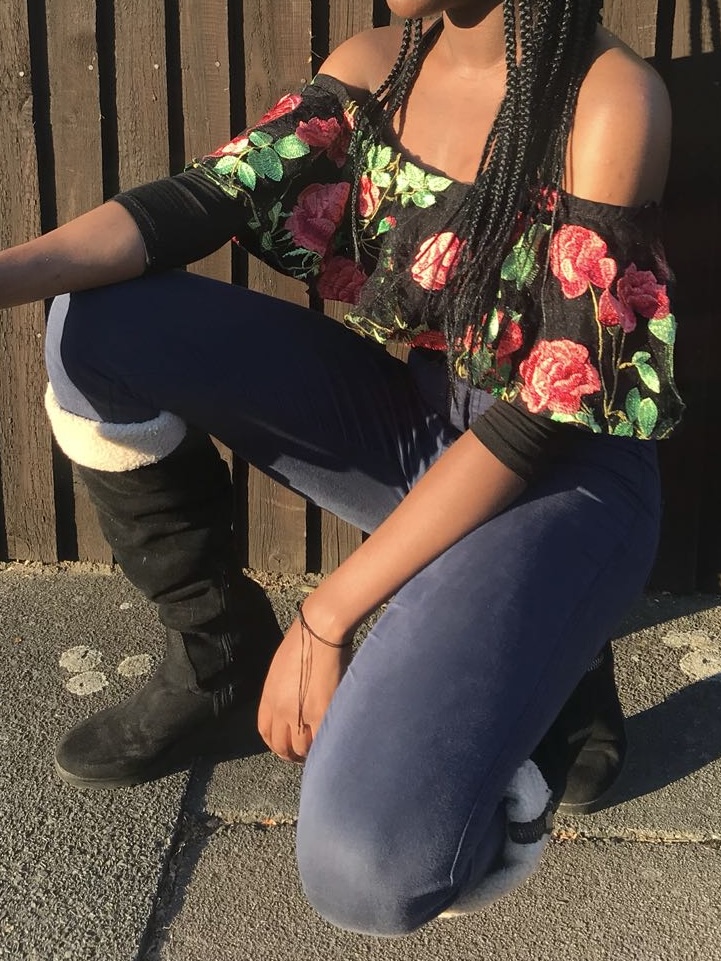 How to actually develop a personal style Photo of me wearing blue skinny jeans, black fur boots, and a black floral bodysuit, showcasing a cozy-meets-feminine outfit that reflects my exploration of texture and bold prints.