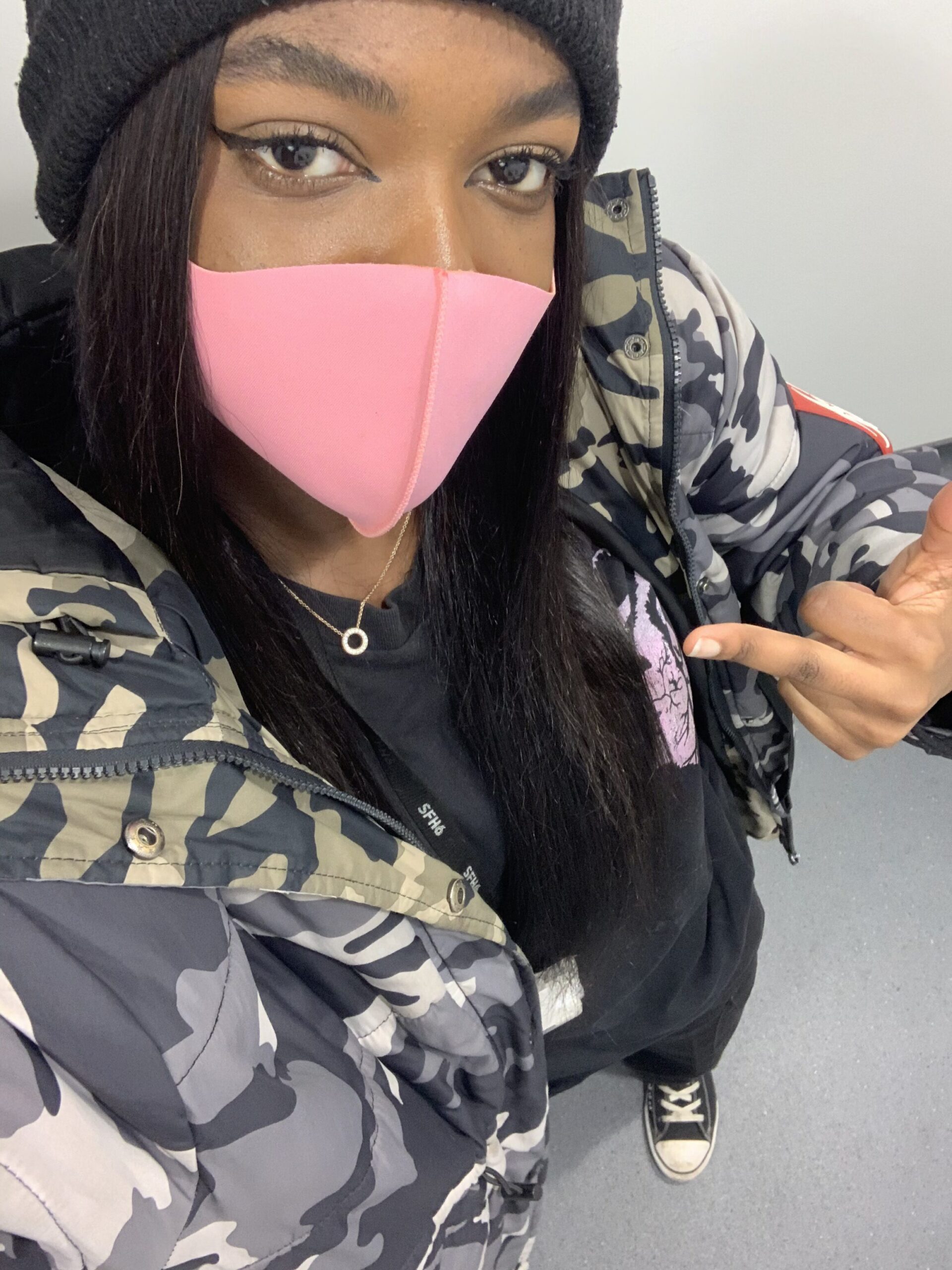 How to actually develop a personal style Photo of me in an oversized camo puffer jacket, black graphic tee, cargo pants, and black Converse, highlighting a bold streetwear look that reflects the more experimental phases of my personal style journey.