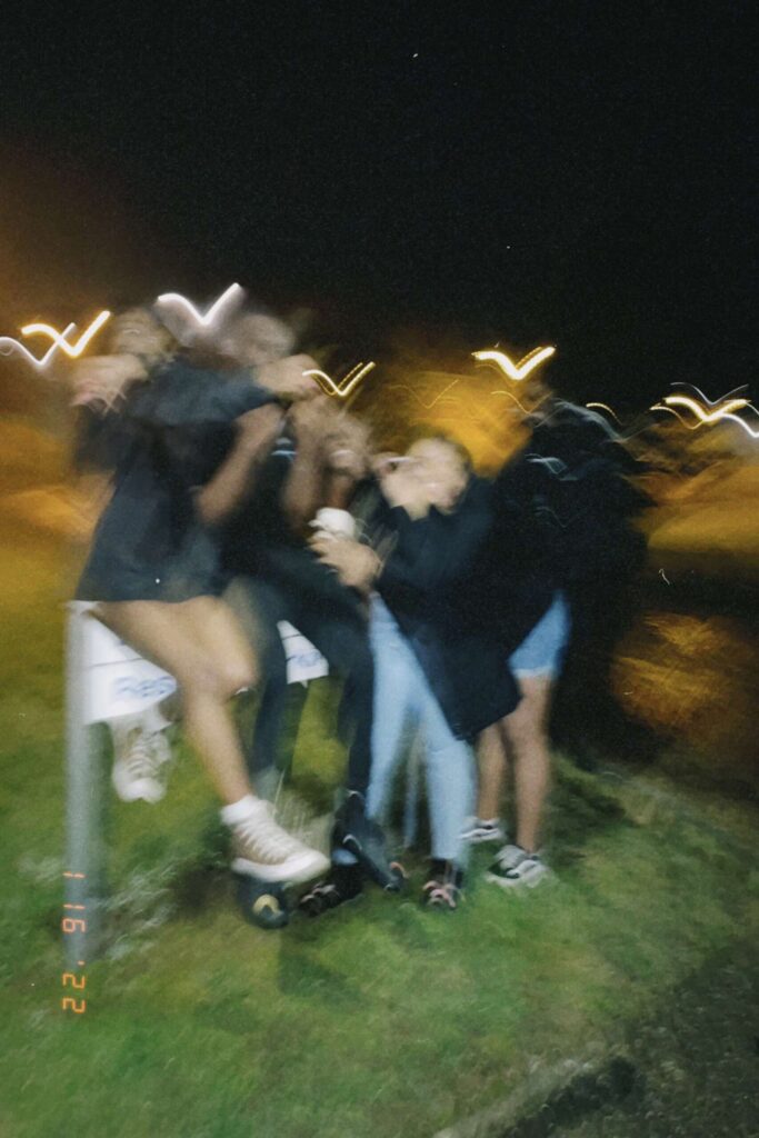 Blurred photo of a group of Black university friends posing together on campus at their home university