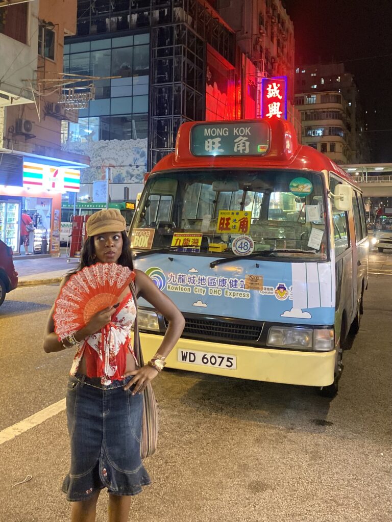 intage-inspired outfit with a jean midi skirt, white and red floral top, red Chinese fan, and baker boy hat